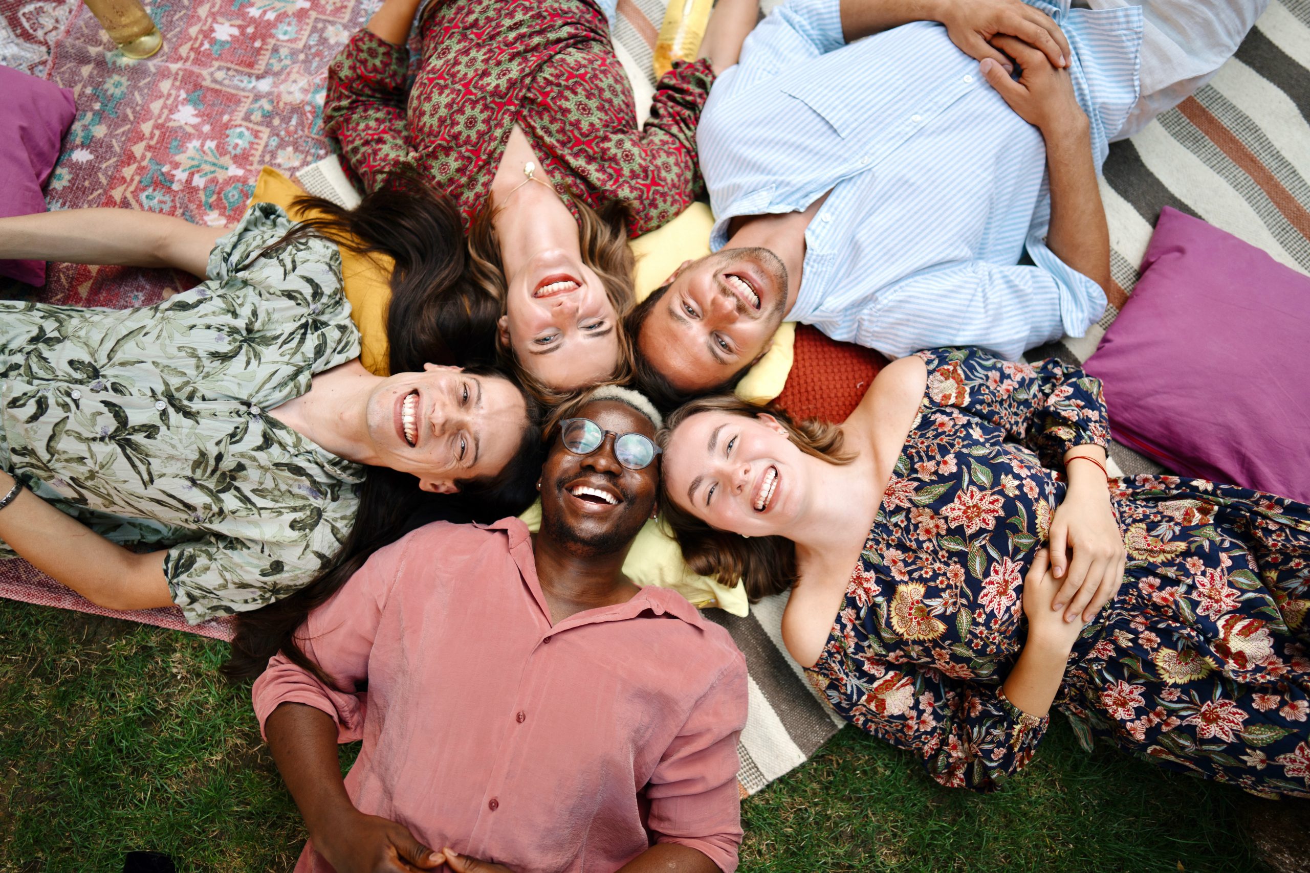 Portrait of beautiful multiracial people lying on the floor in the backyard